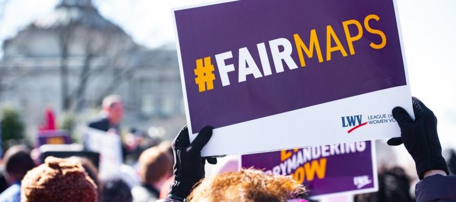 Fair Maps Logo on sign being held by someone in a crowd